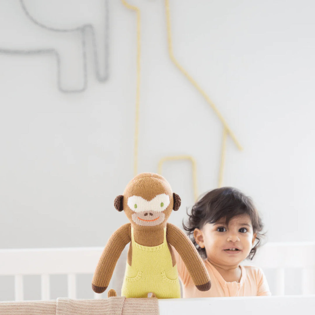 Bébé avec Peluche tricoté yoyo le singe