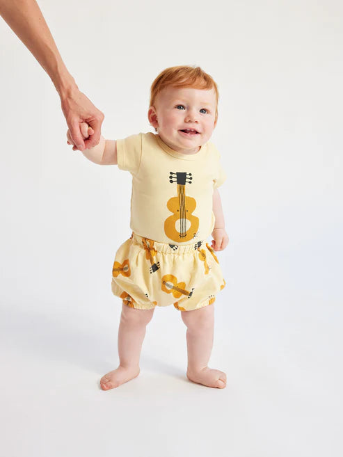 Bébé avec Cache-couche en coton jaune avec guitares acoustiques 