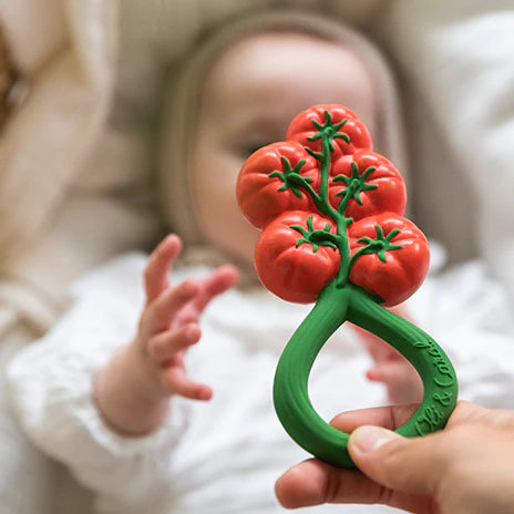 Bébé avec hochet et anneau de dentition en forme de tomates