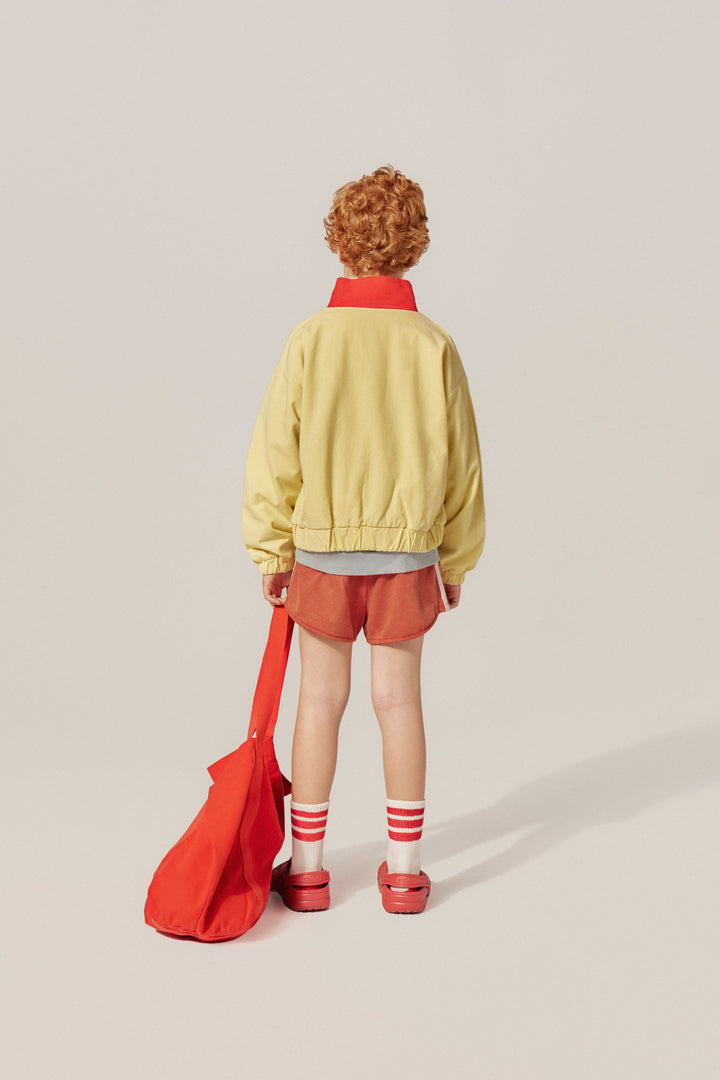 Garçon avec Short sportif en coton rouge délavé