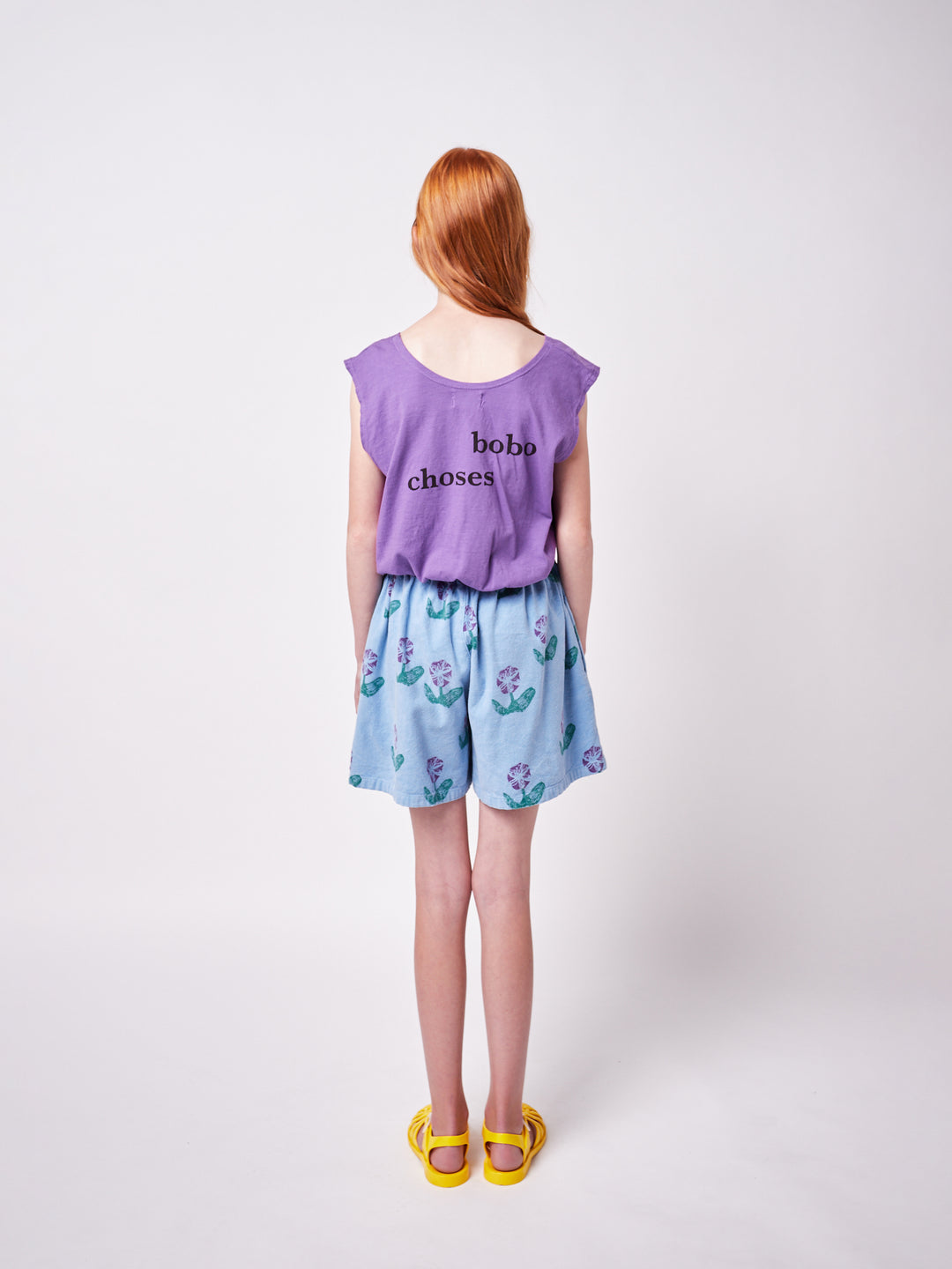 girl wearing Bobo Choses tee and blue woven culotte with purple floral print back