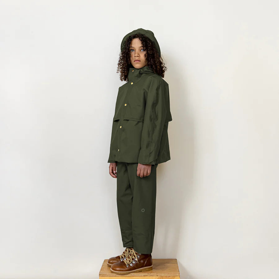 Kid posing wearing fairechild raincoat for kids in pine manteau imperméable pour enfant couleur pin