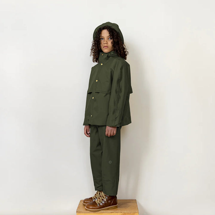Kid posing wearing fairechild raincoat for kids in pine manteau imperméable pour enfant couleur pin