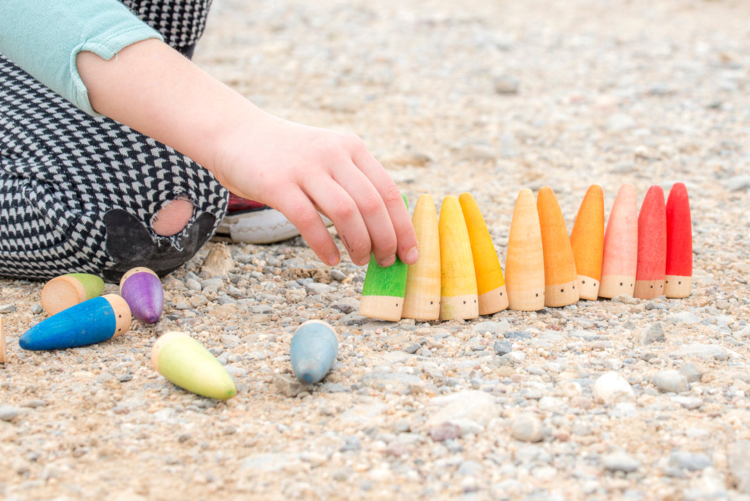 Enfant qui joue avec Grapat - Gnomes à bâtons en bois multicouleurs