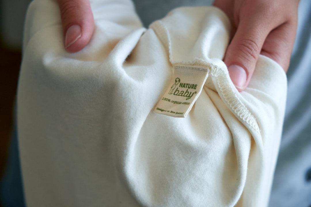 close-up of white fabric with tag ''100% organic cotton Nature Baby''